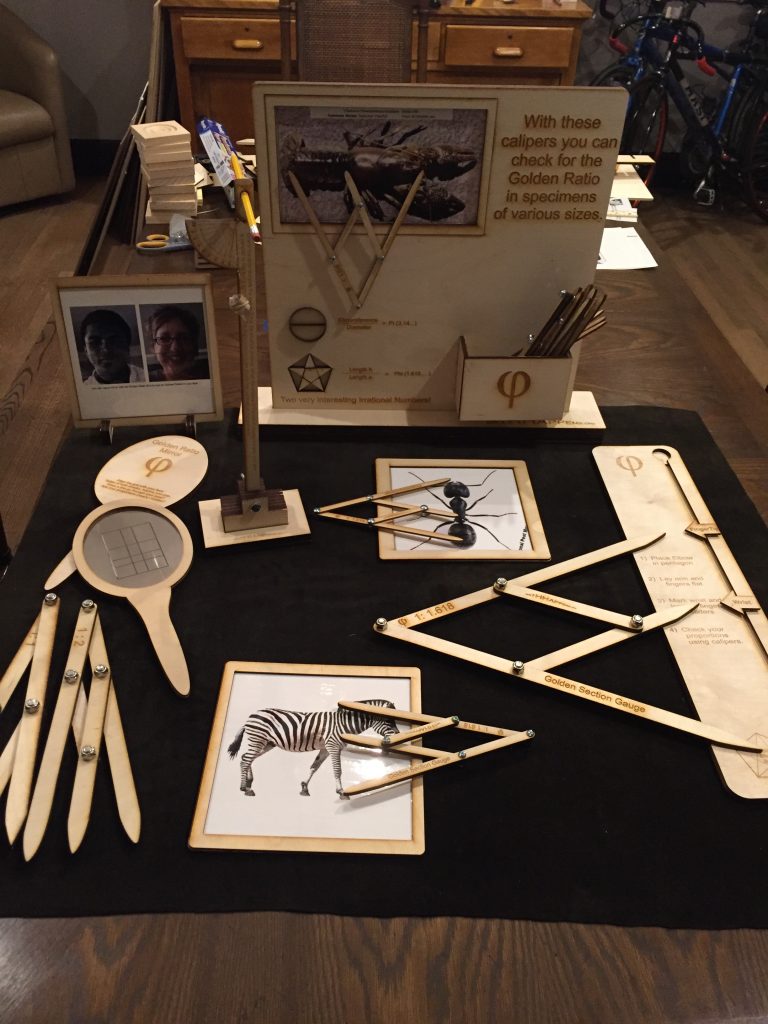 A table covered with calipers and other measuring devices, and laminated nature photographs.