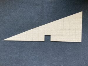 The same pieces as in the above image; rearranged so that the small triangle sits on the left, the larger triangle sits on top, and the two irregular hexagonal pieces nest but leave open one square inch.