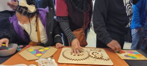 A young child and two adults play with mathematical models on a table at NAAM.
